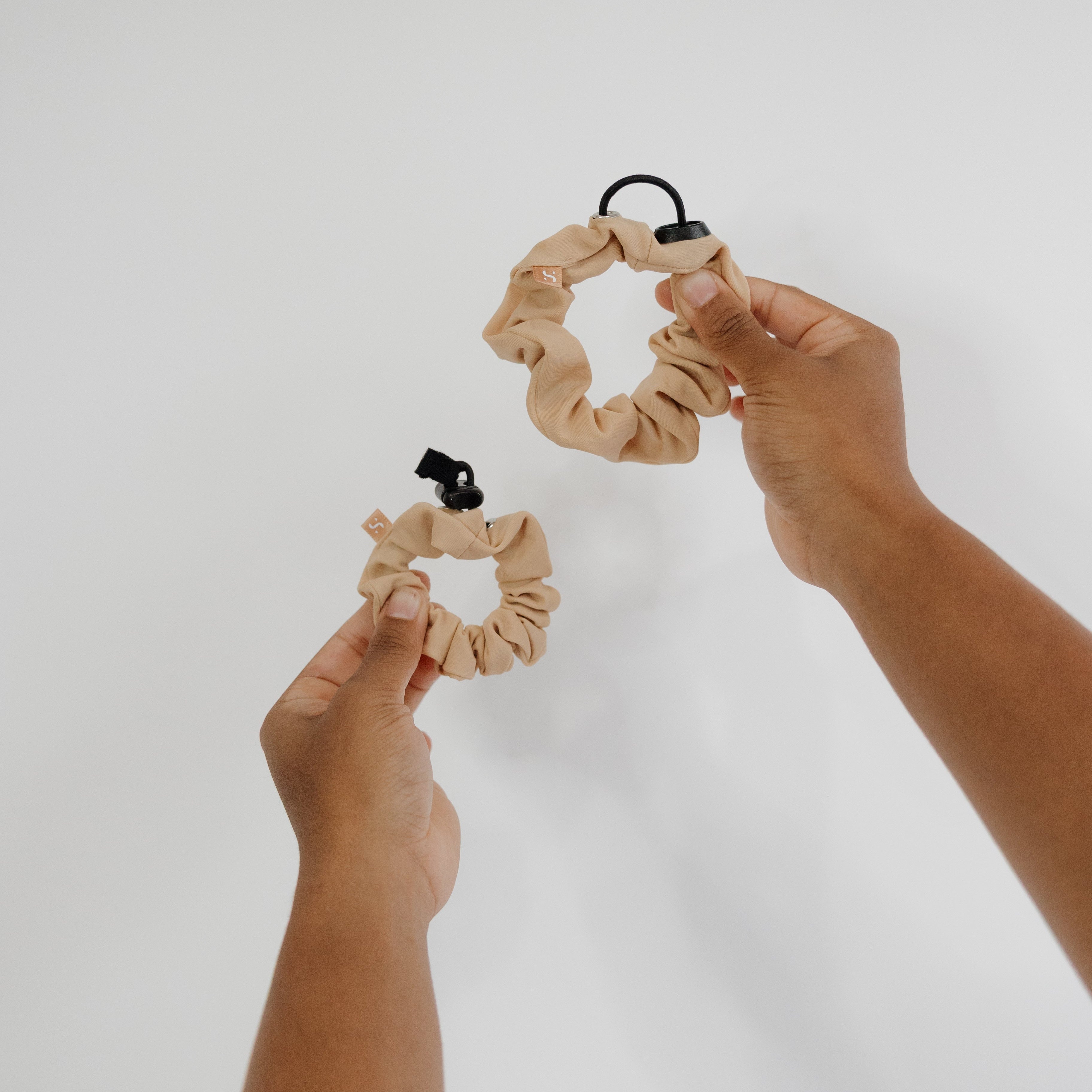 two athletic scrunchies held up two different sizes