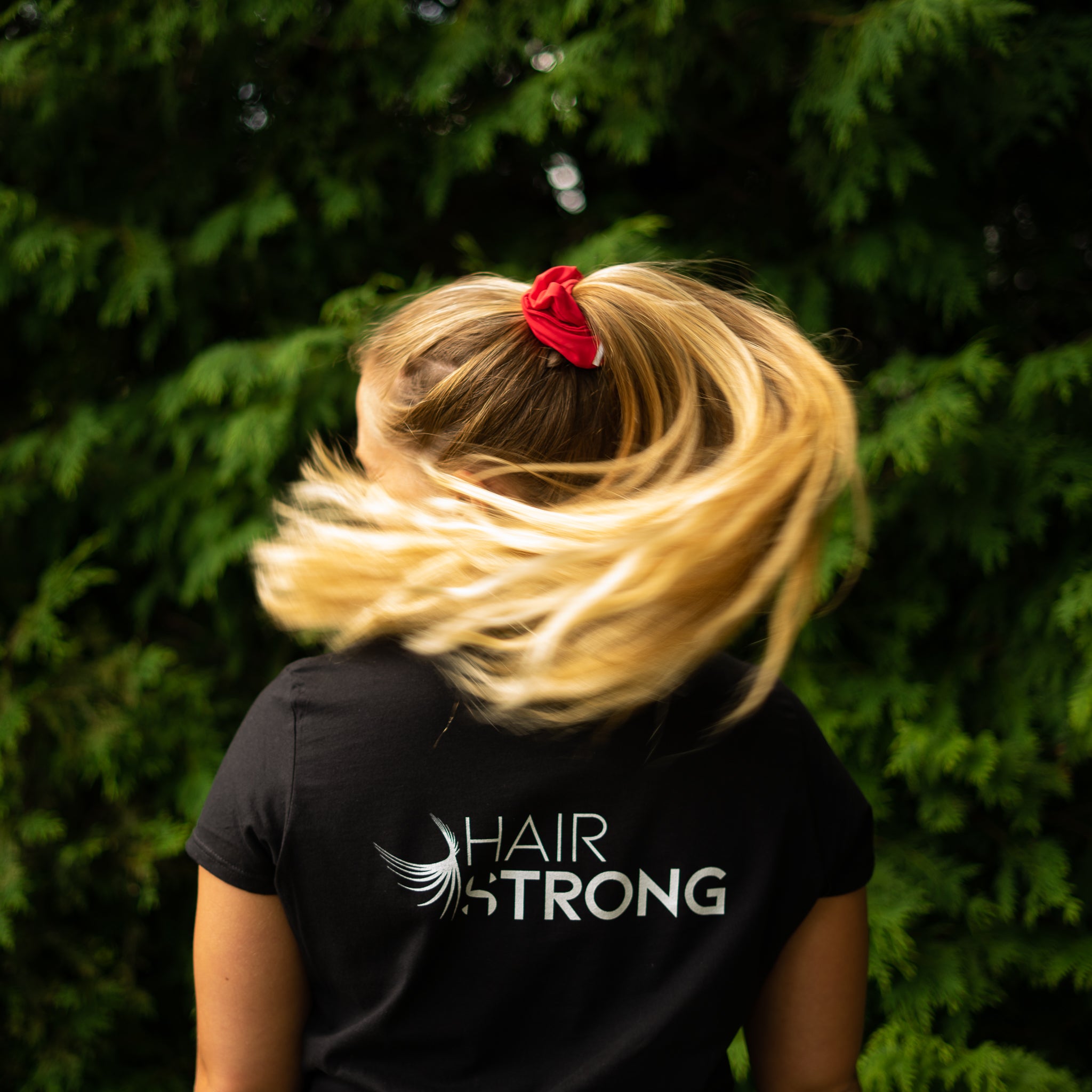  blonde hair ponytail wearing a hairstrong red scrunchie 