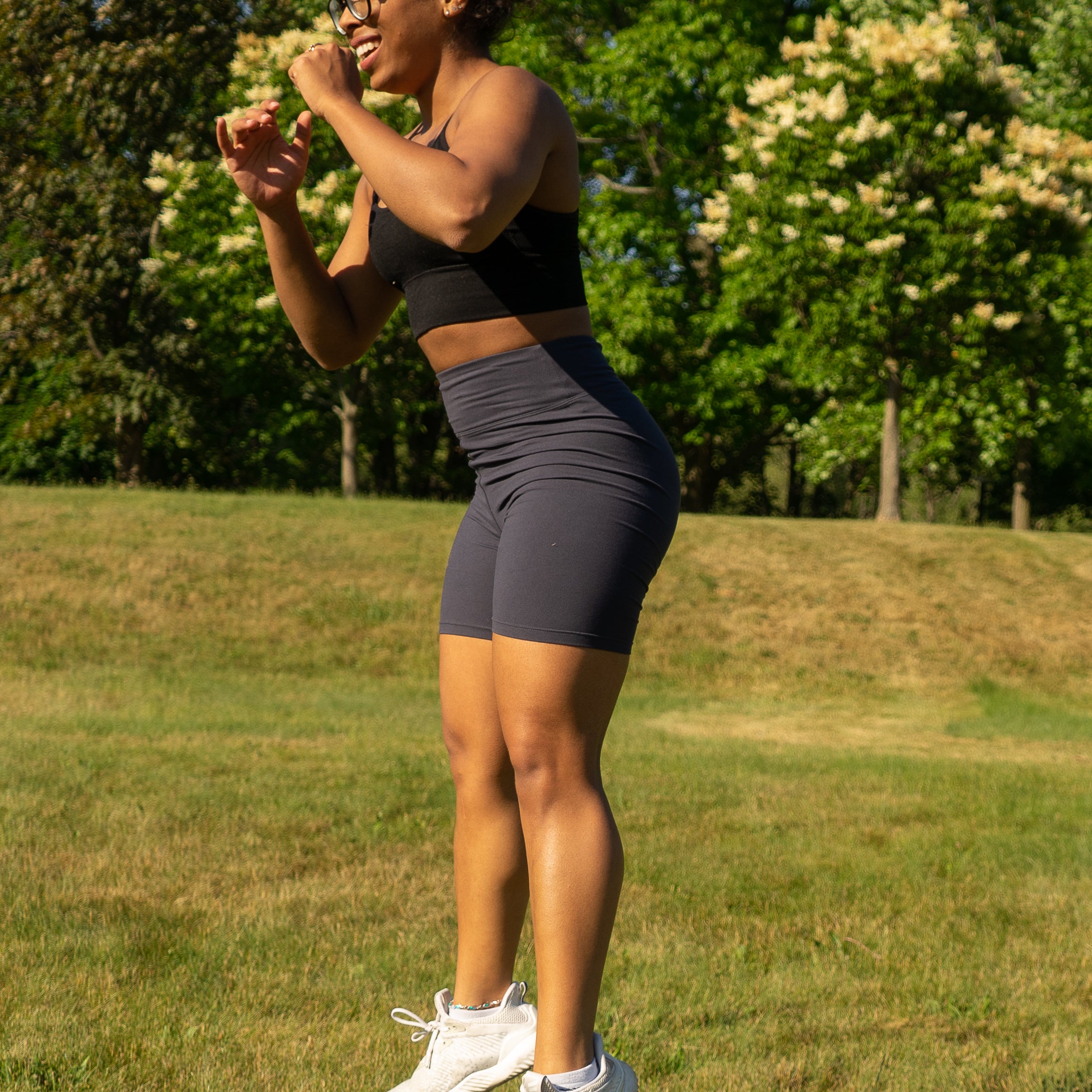 Women with curly hair jumping and wearing a hairstrong scrunchie in a high ponytail 