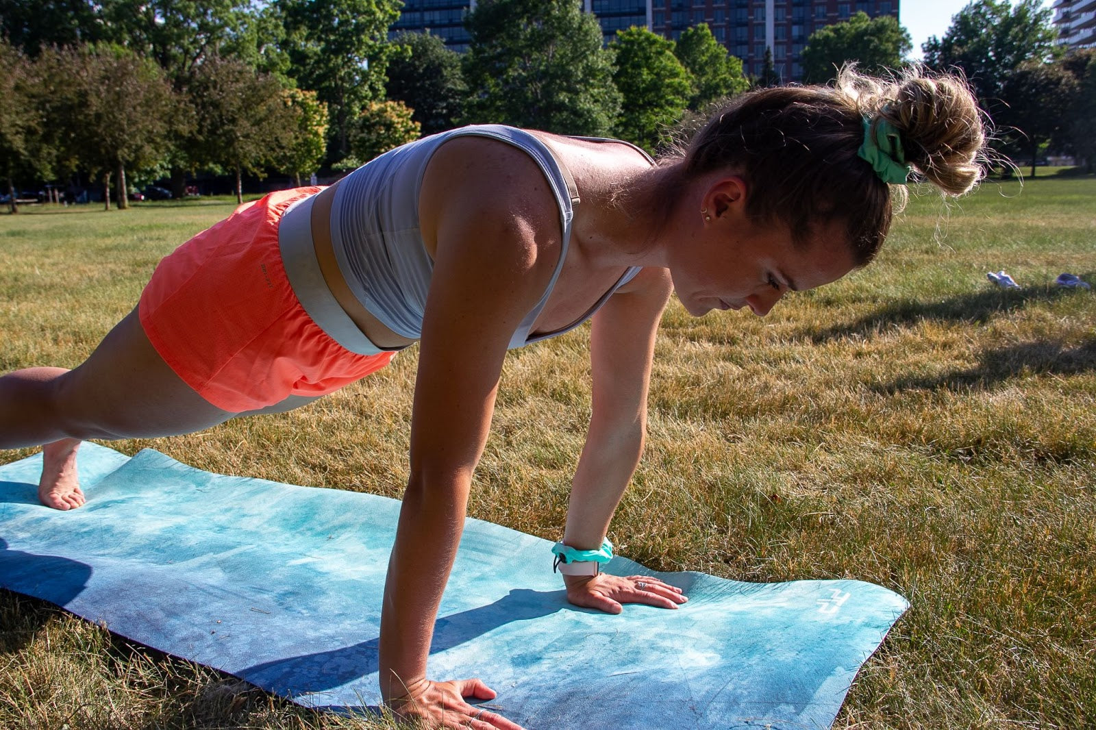 Women planking on yoga mat with her hair in a bun wearing a hairstrong scrunchie